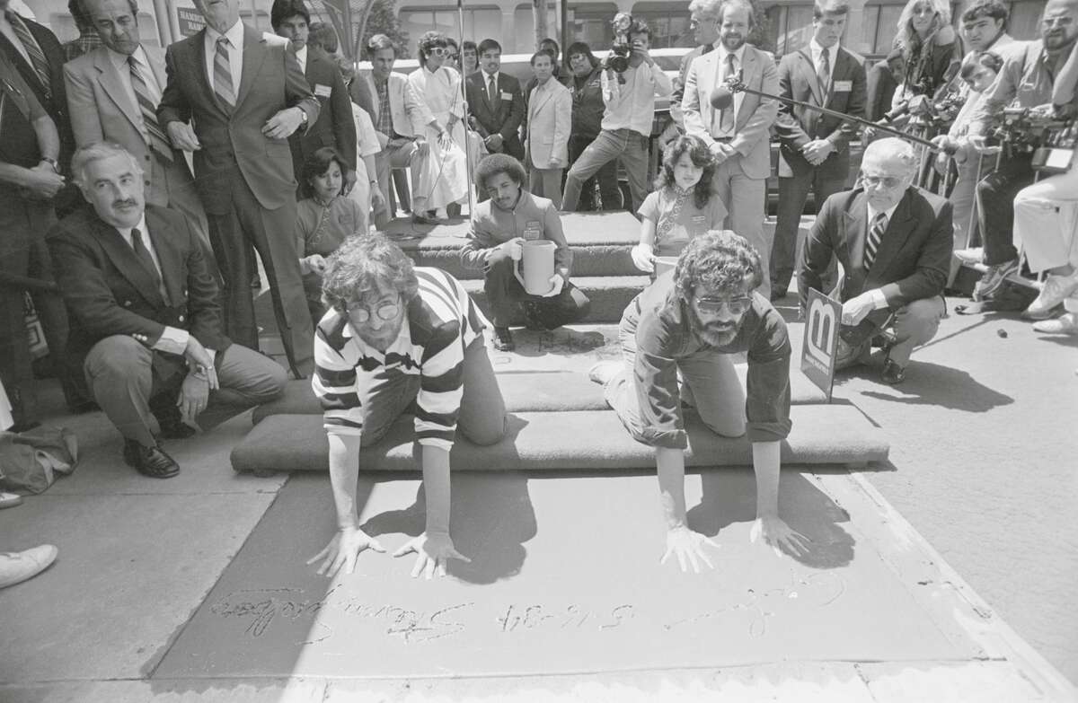 George Lucas (derecha) y Steven Spielberg colocan sus manos y pies en cemento en la explanada del Teatro Chino de Mann el 16 de mayo de 1984.