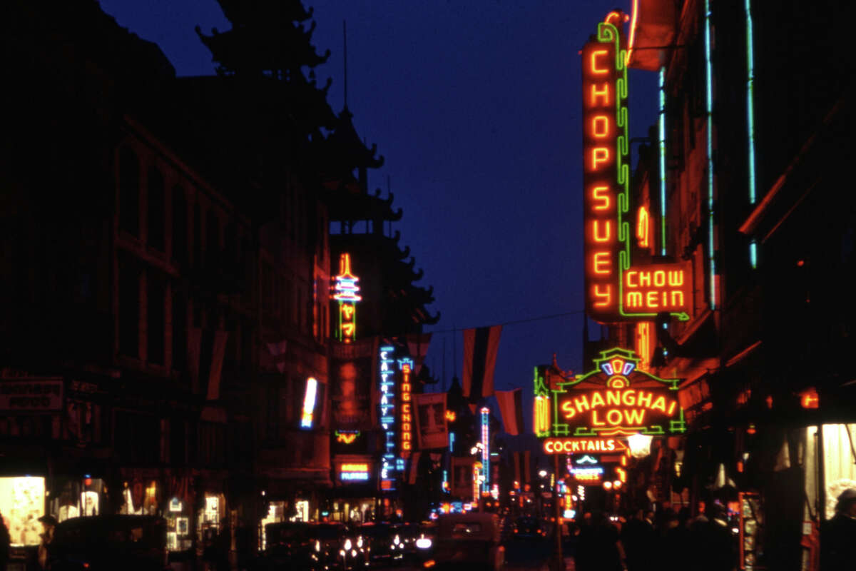 Una foto de película de 35 mm muestra una calle en el barrio chino de San Francisco, donde varios negocios, incluido Shangai Low, se iluminan con neón cuando la hora azul se convierte en noche, 1940. 