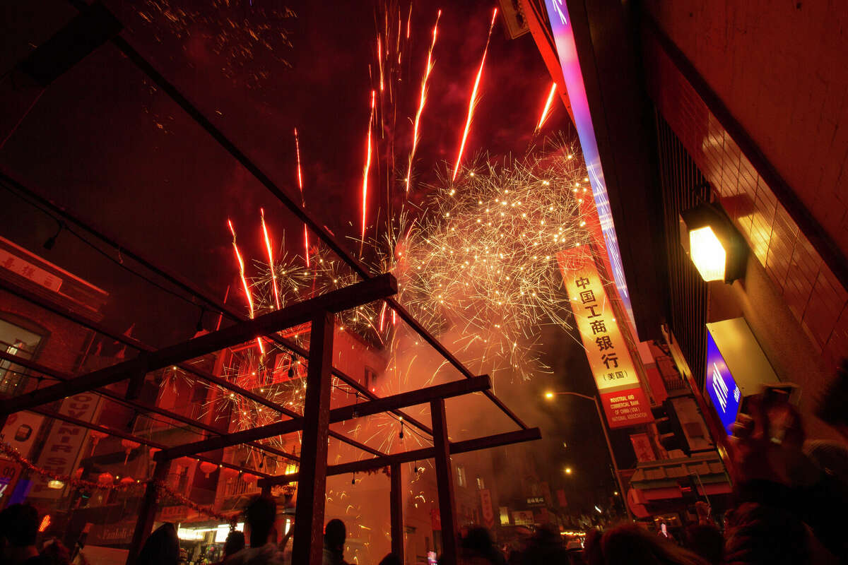 Coloridos espectáculos de fuegos artificiales iluminan el cielo de la víspera del Año Nuevo Lunar en la intersección de Grant Avenue y Jackson Street en medio de festividades en Chinatown el sábado 21 de enero de 2023 por la noche.