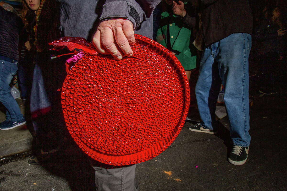 Un hombre se para con una bobina de petardos en la intersección de Grant Avenue y Jackson Street durante las celebraciones del Año Nuevo Lunar en Chinatown el sábado 21 de enero de 2023 por la noche.