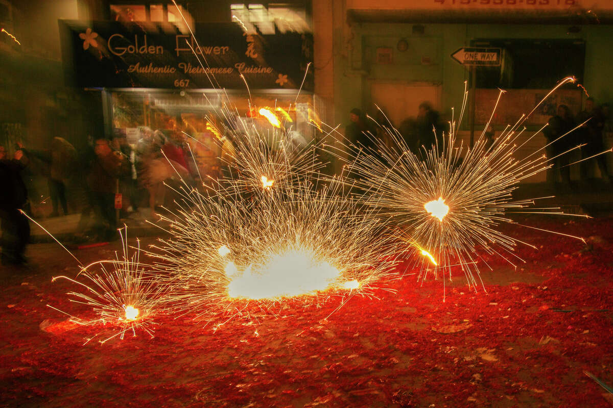Filas de fuegos artificiales se encienden en la intersección de Grant Avenue y Jackson Street durante las celebraciones del Año Nuevo Lunar en Chinatown el sábado 21 de enero de 2023 por la noche.