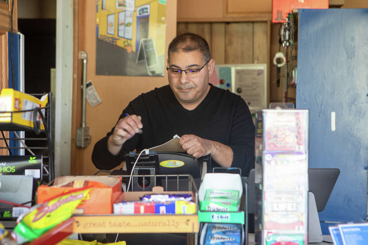 El propietario Jesse Ganim trabaja detrás de la caja registradora en Ganim's Market en el vecindario Potrero Hill de San Francisco, California, el 12 de enero de 2022.