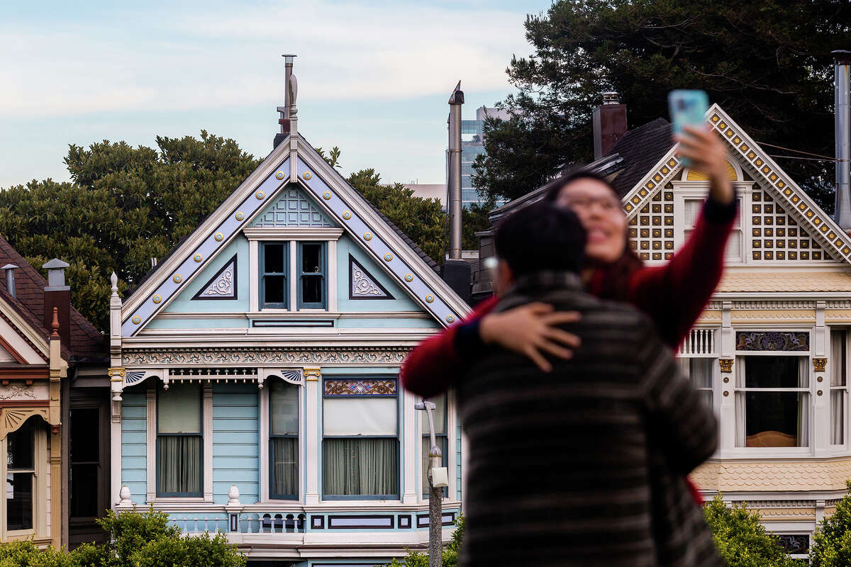 Los turistas se toman una selfie frente a las Damas Pintadas. San Francisco es el hogar de muchos victorianos, incluidas las casas de colores pastel en Steiner Street.