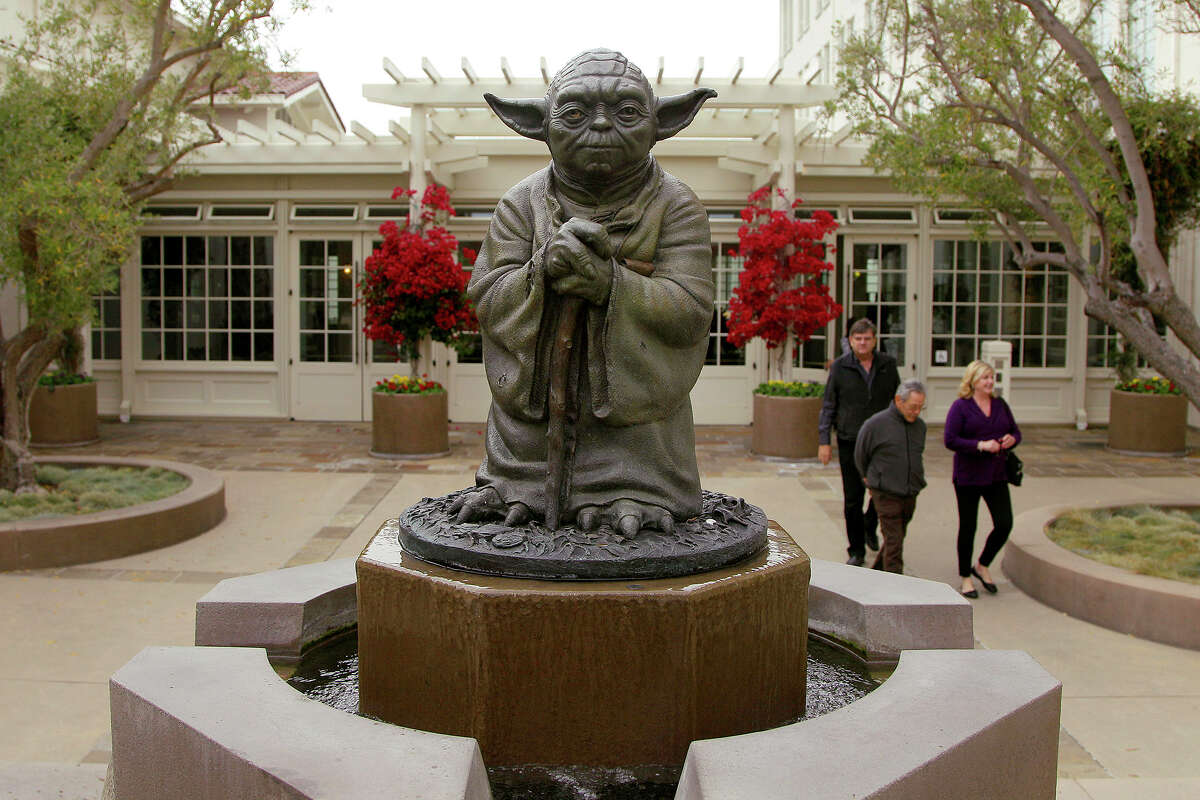 La gente pasa junto a una estatua de Yoda del "Guerra de las Galaxias" películas fuera de la sede de Lucasfilm en San Francisco.