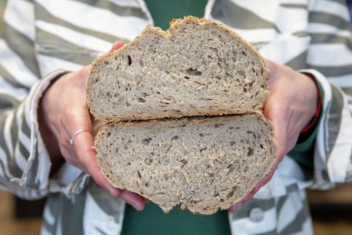 La nueva propietaria de Lehr's German Specialties, Hannah Seyfert, sostiene un pan de trigo y centeno que es uno de los alimentos alemanes disponibles en su tienda en Noe Valley de San Francisco, California, el 29 de enero de 2023.