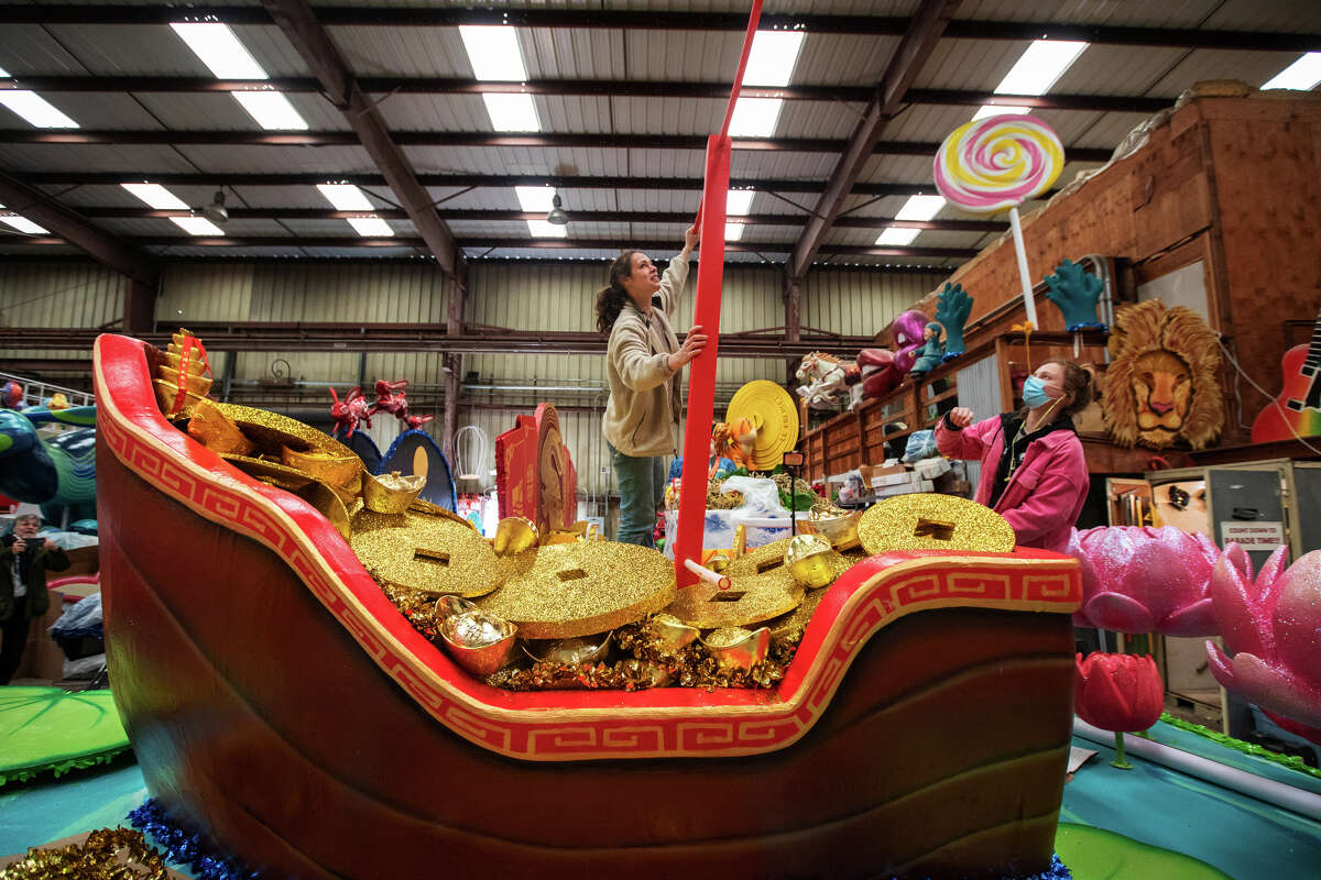 Stephanie Mufson, centro, ayuda a Hannah Wise a trabajar en un bote de monedas de oro en un almacén en el Muelle 54 en San Francisco el 30 de enero de 2023. Mufson lidera un equipo que construye carrozas que participarán en el Desfile del Año Nuevo Chino. 