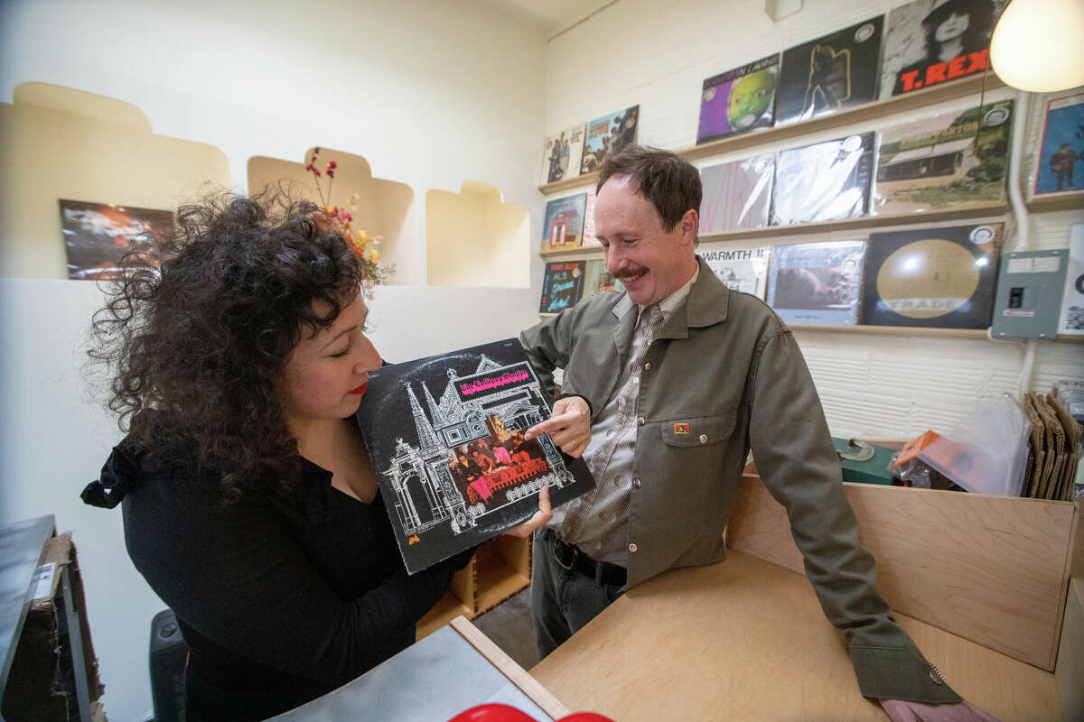 (De izquierda a derecha) Hannah Lew y Andrew Kerwin, copropietarios de Contact Records, hablan sobre uno de los raros discos que tienen a la venta en Lollipop Shoppe, que recientemente abrió una nueva ubicación en Temescal Alley en Oakland, California, el 14 de febrero de 2023. .