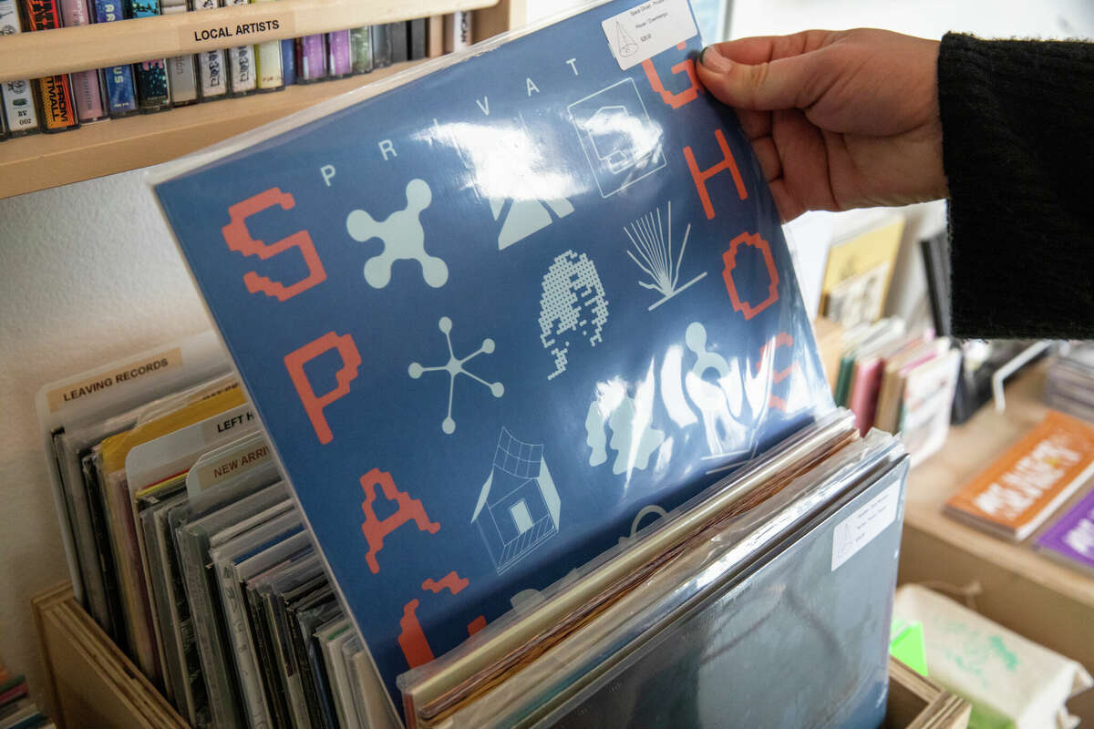Matt Brownell tiene un récord del artista electrónico local de Oakland Space Ghost en la tienda de discos Cone Shape Top en Oakland, California, el 14 de febrero de 2023.