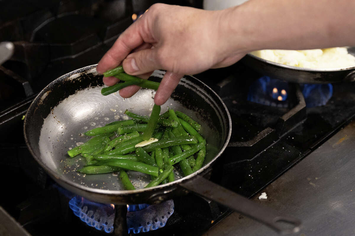 El chef ejecutivo Chris Hui cocina unas judías verdes con ajo en el Gold Club de San Francisco el 28 de febrero de 2023. 