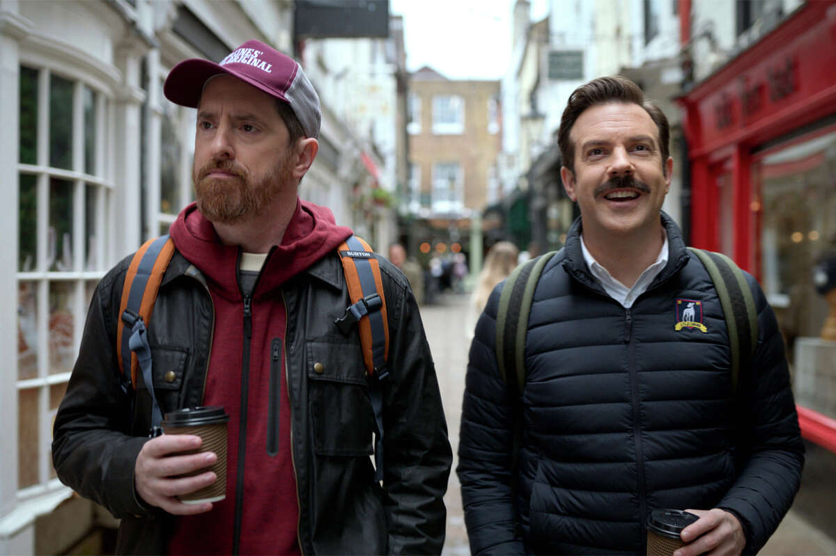 Brendan Hunt, a la izquierda, y Jason Sudeikis caminan por el distrito londinense de Richmond upon Thames en la primera temporada de Apple TV. "Ted Lasso."