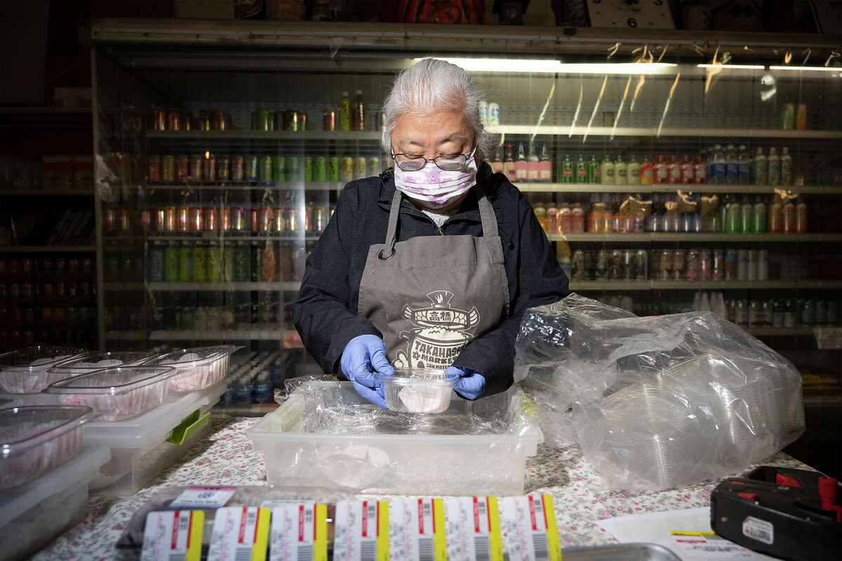 Phylis Takahashi empaqueta Dango fresco de Shuiei-Do (empanadillas japonesas dulces de arroz) en el mercado de Takahashi en San Mateo, California, el 9 de marzo de 2023