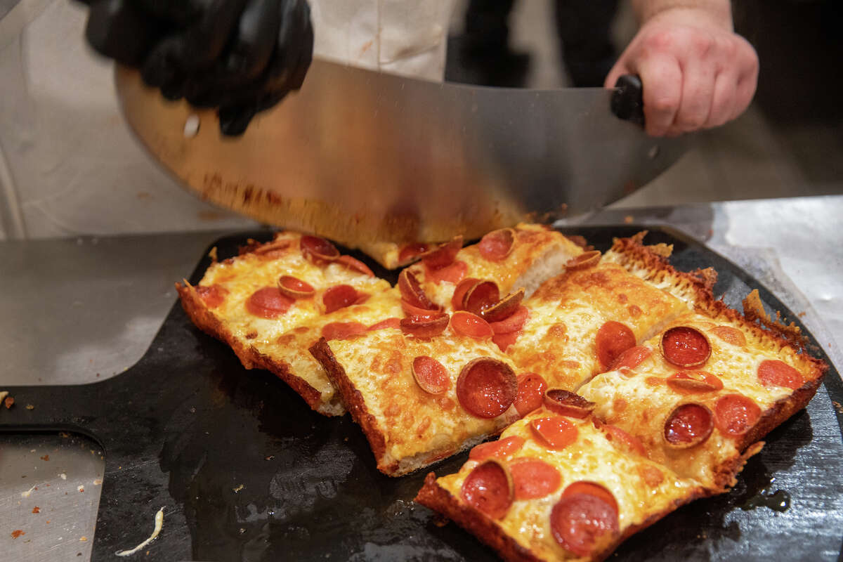 El personal de cocina Sydd Urgola corta una pizza estilo Detroit en Pizzeria da Laura en Berkeley, California, el 23 de marzo de 2023.