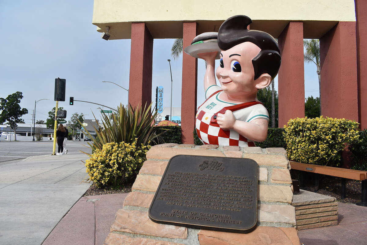 Una placa que conmemora el estatus histórico de Bob's Big Boy en Burbank, California, recibe a los visitantes junto con la icónica mascota Big Boy del restaurante.