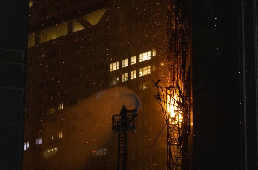  Los bomberos luchan contra un incendio en un distrito comercial de Hong Kong