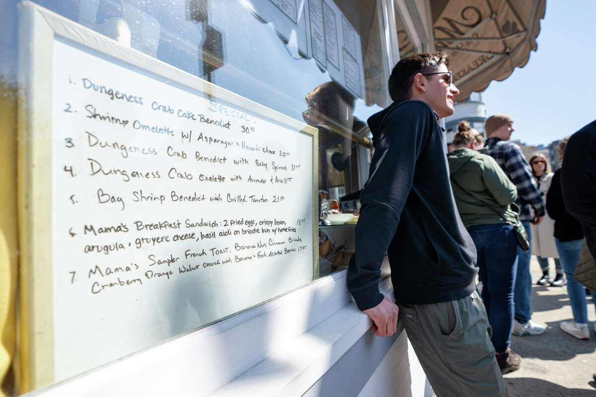 Se muestra un tablero de ofertas especiales con una selección de productos para el desayuno mientras los clientes esperan en fila para Mama's On Washington Square en San Francisco, California, el 25 de marzo de 2023.