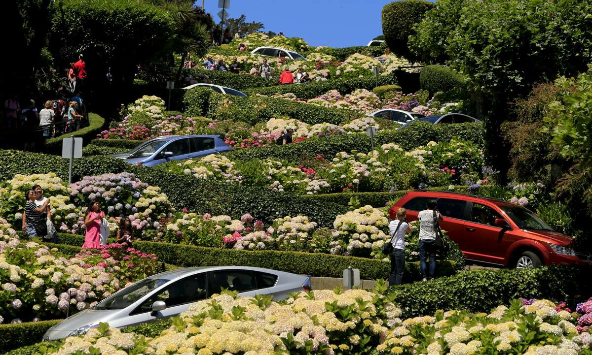 Los autos zigzaguean por Lombard Street en San Francisco pasando arbustos y arbustos perfectamente cuidados el 20 de junio de 2013.