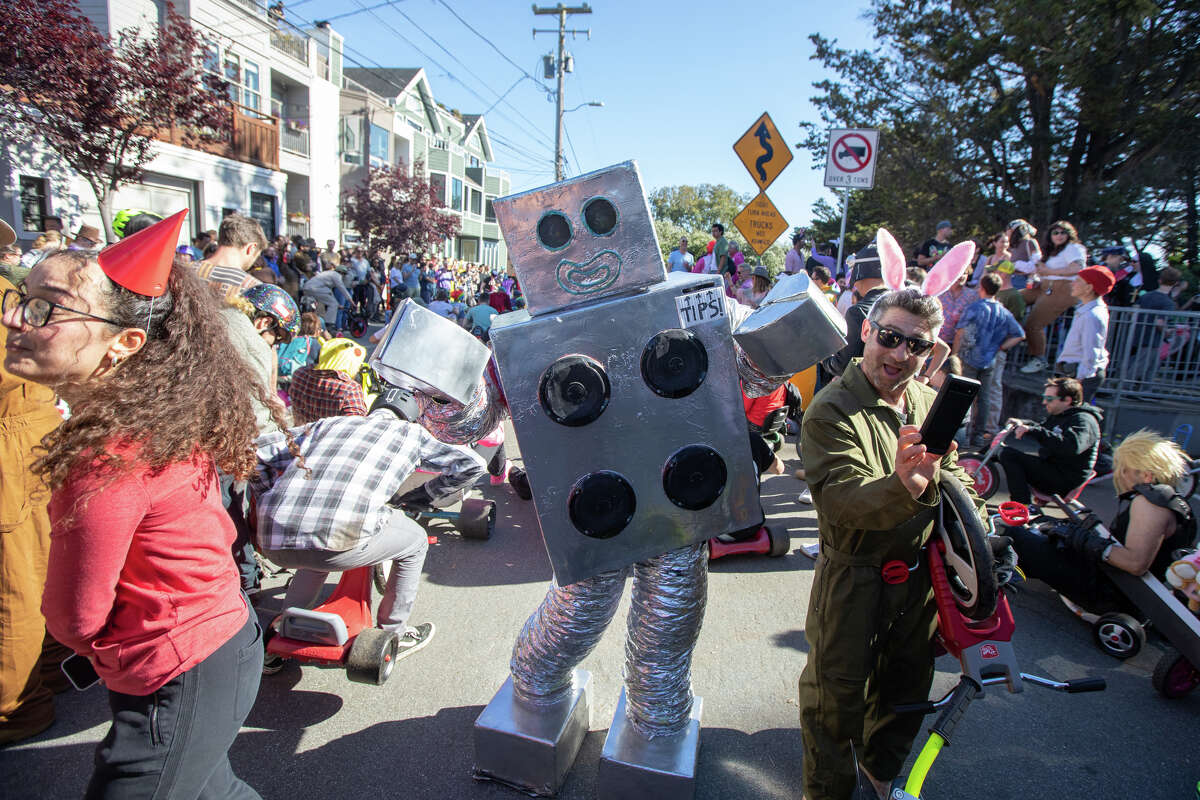 Chris Hirst, el robot bailarín, entretiene a los corredores en la línea de salida del evento de carreras Bring Your Own Big Wheels en Vermont Street en San Francisco, California, el 9 de abril de 2023.