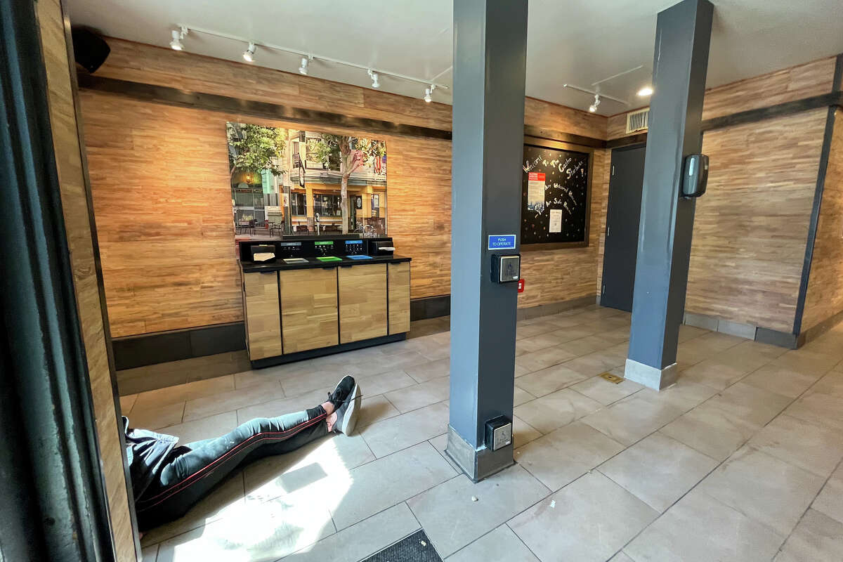 Un hombre yace en el piso dentro de una tienda Starbucks en la calle 18 en el distrito de Castro donde se retiraron todas las sillas para los clientes en San Francisco, California, el 23 de marzo de 2023.