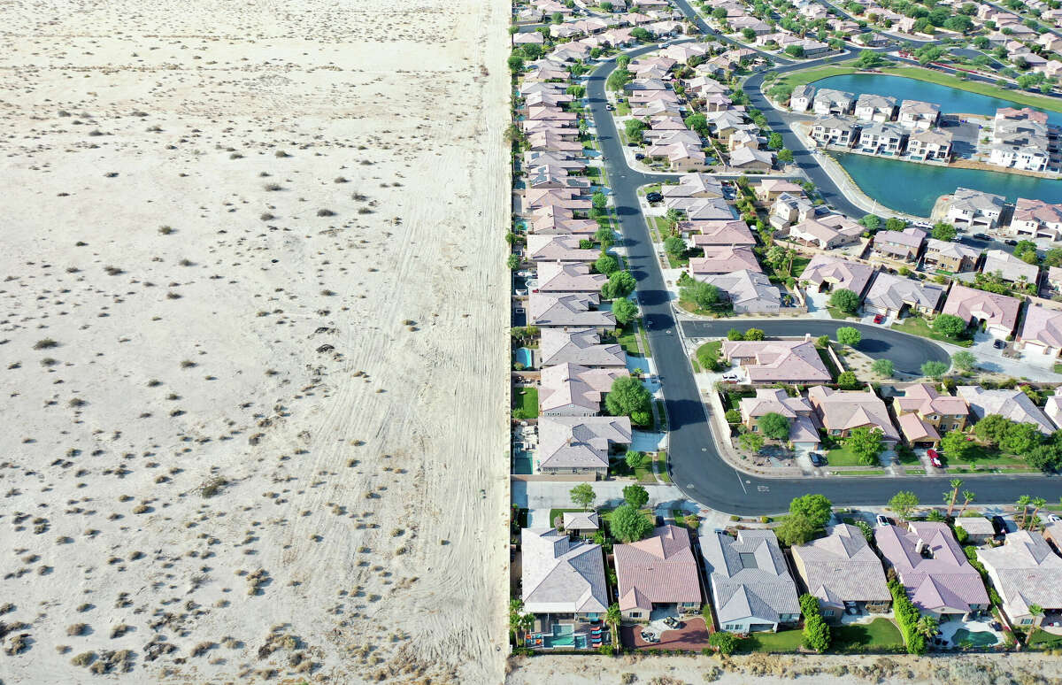 ARCHIVO: Una vista aérea de casas junto al desierto sin desarrollar el 13 de julio de 2022, en Indio, California.