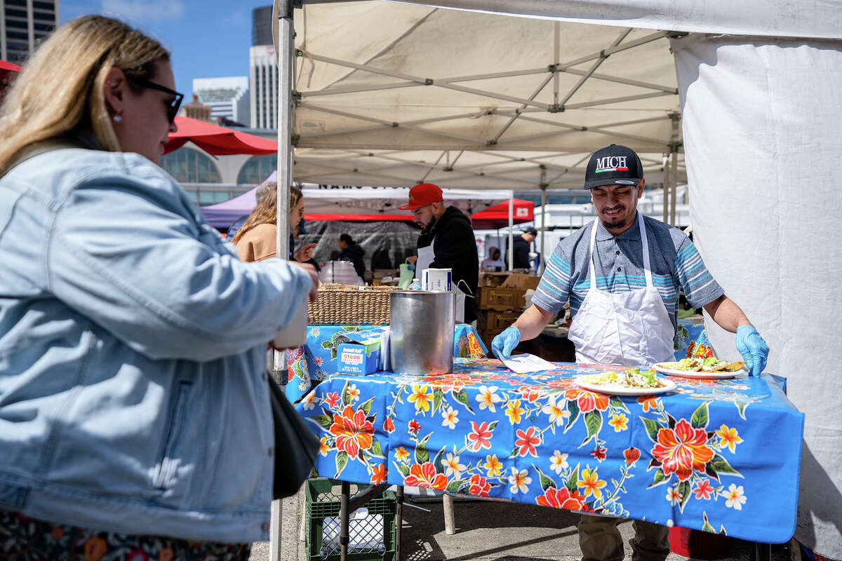 Los empleados entregan comida a los clientes en el puesto Primavera en el Ferry Building Farmer's Market el sábado 15 de abril de 2023.