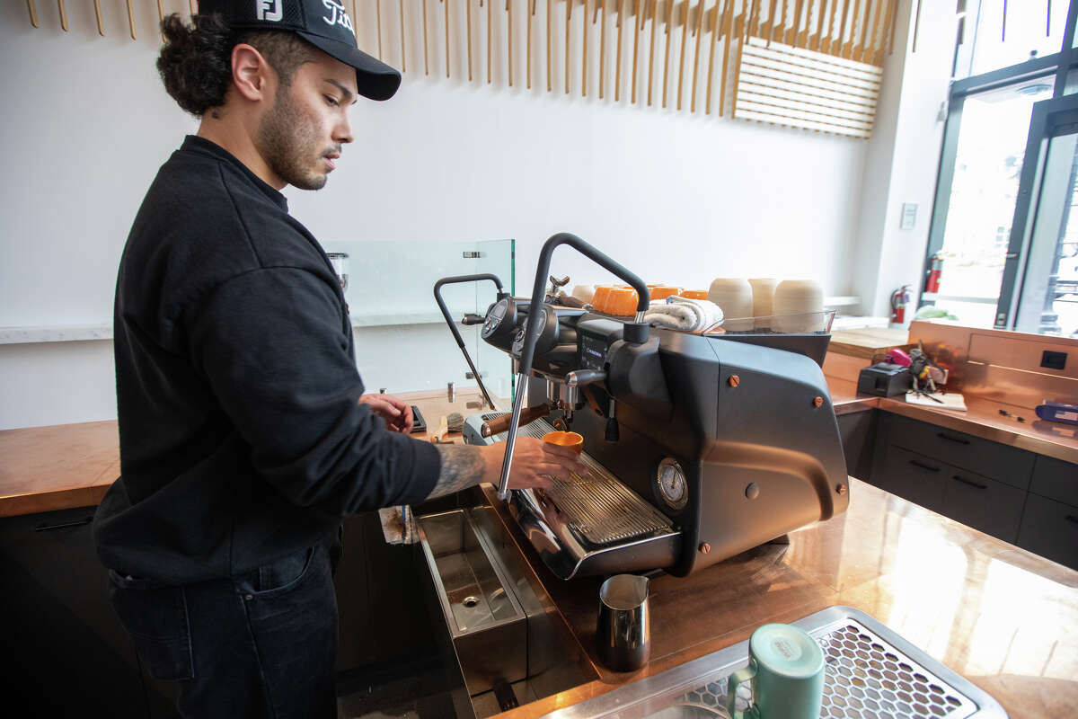 El barista Mehdi Chung prepara un café con leche en el nuevo Caffè by Mr. Espresso en Broadway en el centro de Oakland, California, el 18 de mayo de 2023.