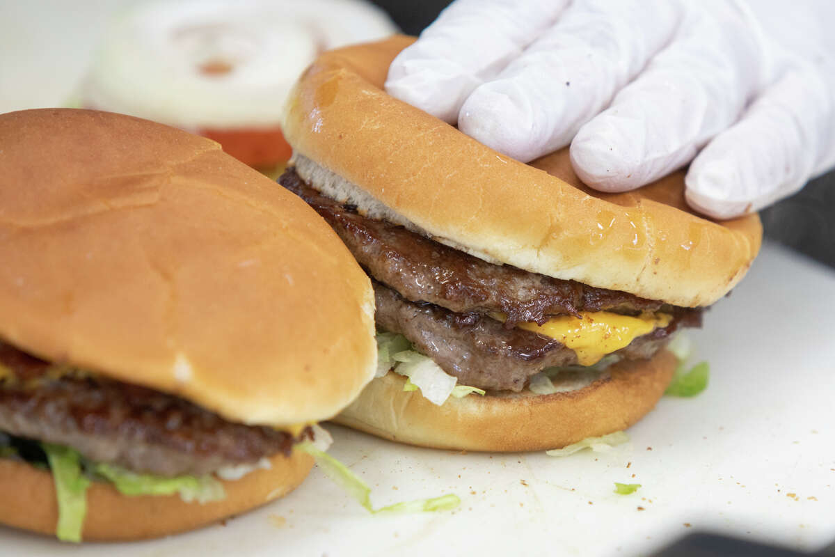 Una hamburguesa con queso y una hamburguesa se ensamblan en Bud's Giant Burgers en Vallejo, California, el 24 de mayo de 2023.