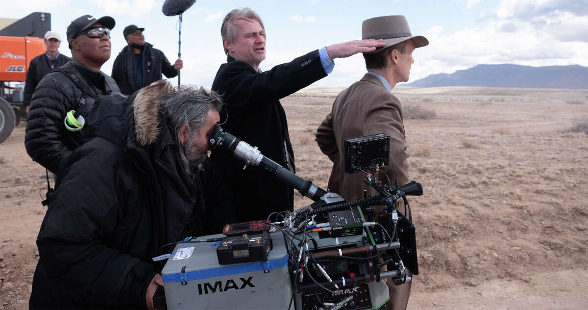 El director Christopher Nolan (centro) se encuentra detrás del actor Cillian Murphy (extremo derecho) en el plató de "Oppenheimer".