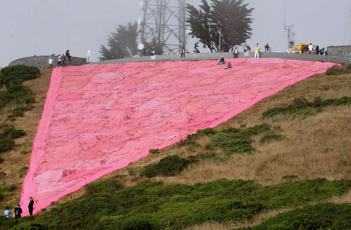 Los voluntarios terminan de instalar el triángulo rosa gigante en Twin Peaks para dar inicio a las festividades del Mes del Orgullo en San Francisco, California.