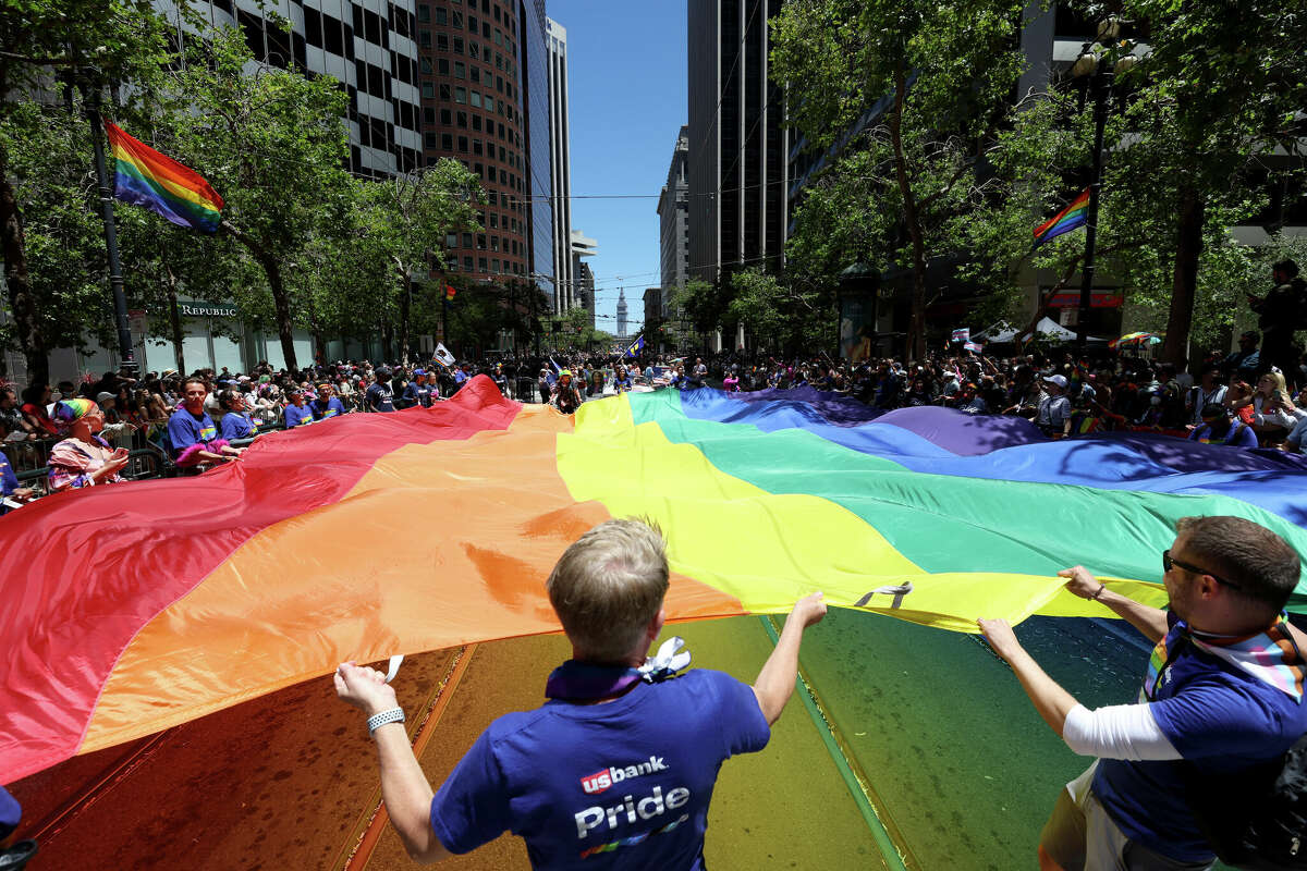 Los manifestantes llevan una bandera arcoíris de gran tamaño durante el 52º Desfile Anual del Orgullo de San Francisco el 26 de junio de 2022 en San Francisco,California 