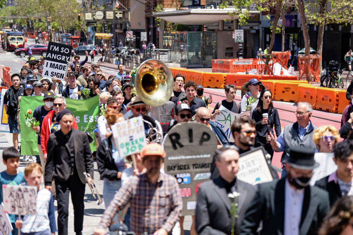 Una multitud de asistentes al Funeral de Tránsito y partidarios de la financiación del transporte público marchan por Market Street en el centro de San Francisco, California, el 3 de junio de 2023.