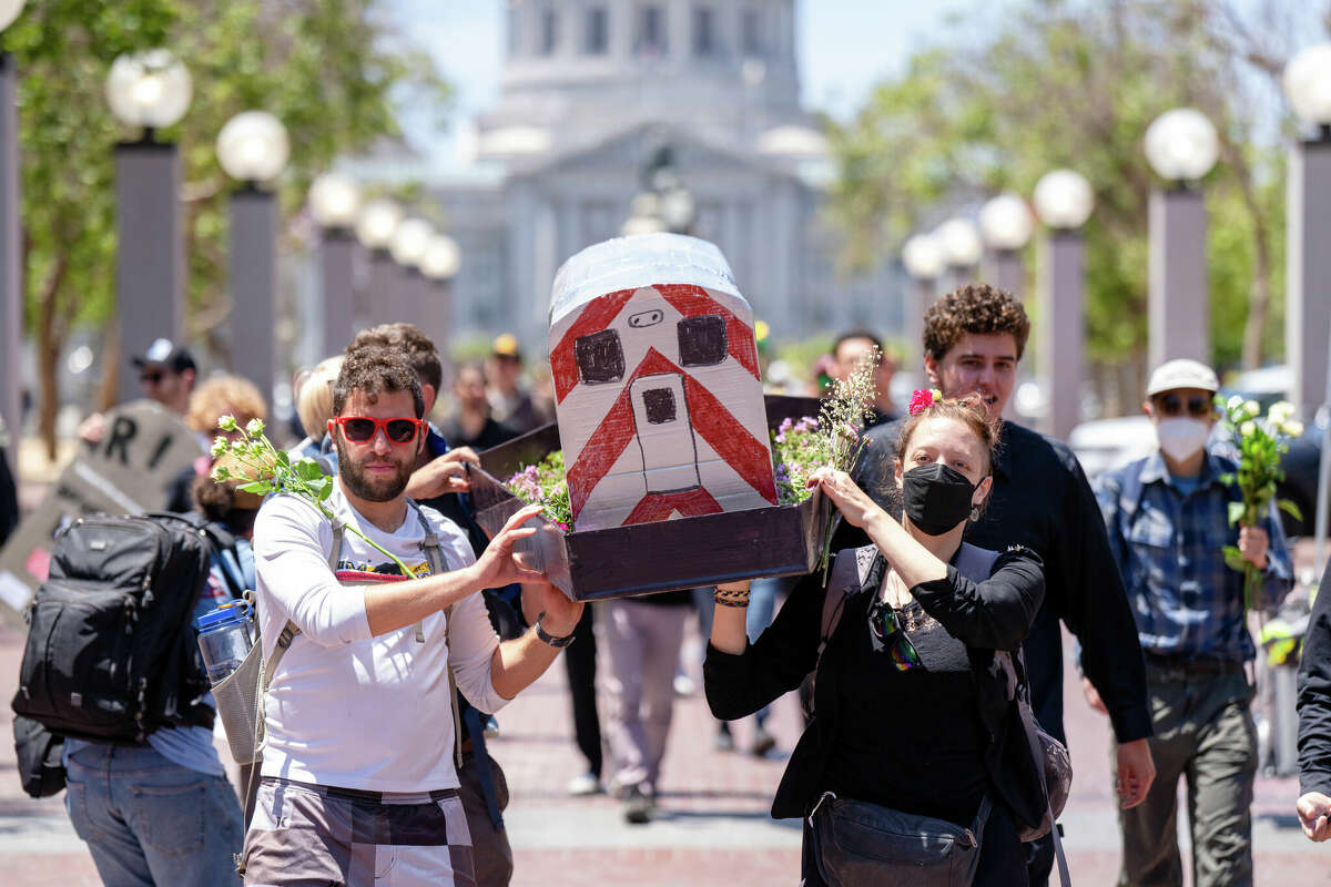 Los asistentes a Transit Funeral sostienen un ataúd de Cal Train y recorren el Centro Cívico en San Francisco, California, el 3 de junio de 2023.