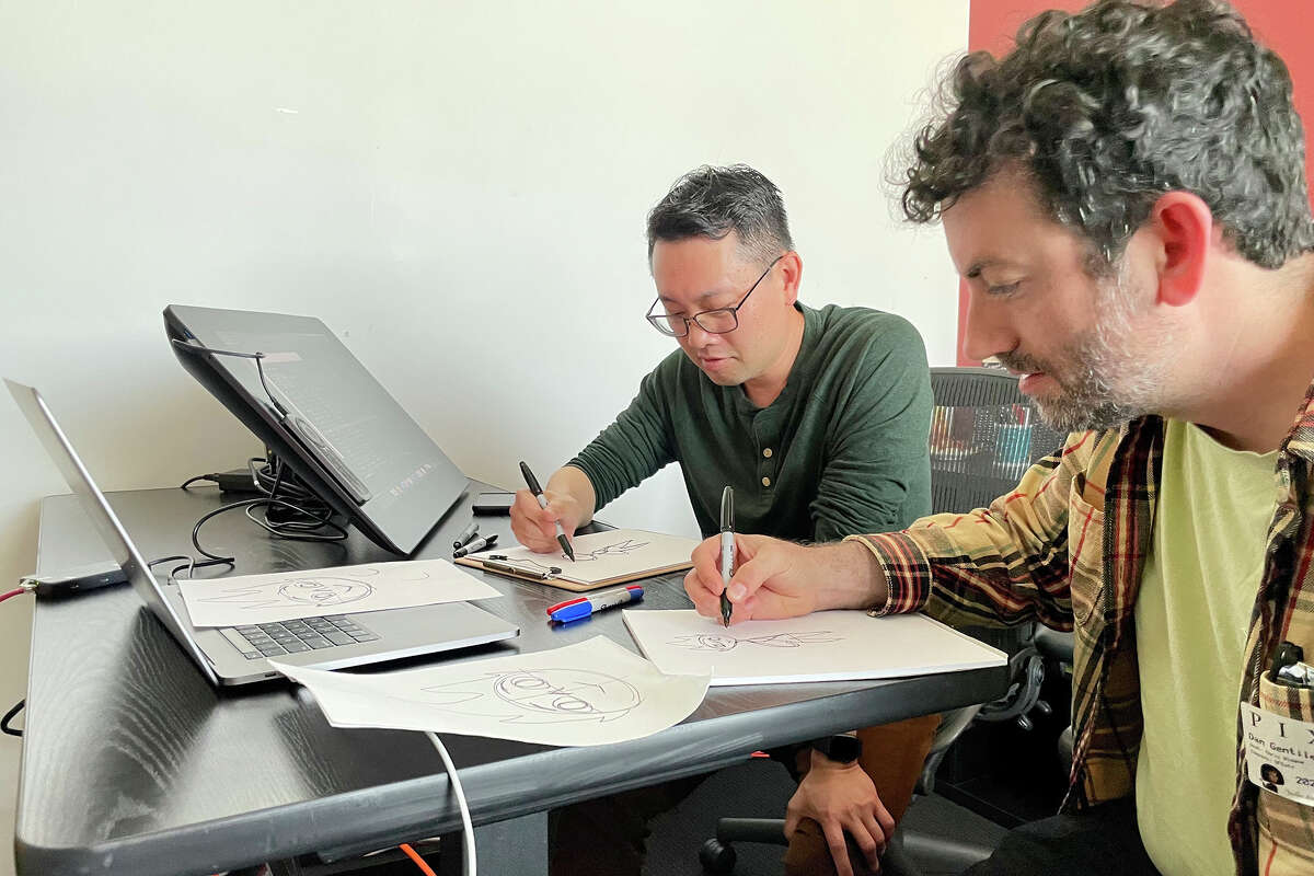 El editor de cultura de SFGATE, Dan Gentile, a la derecha, recibe una lección de dibujo del artista principal de la historia de Pixar, Le Tang, en la sede de la compañía en Emeryville, California, el 5 de junio.