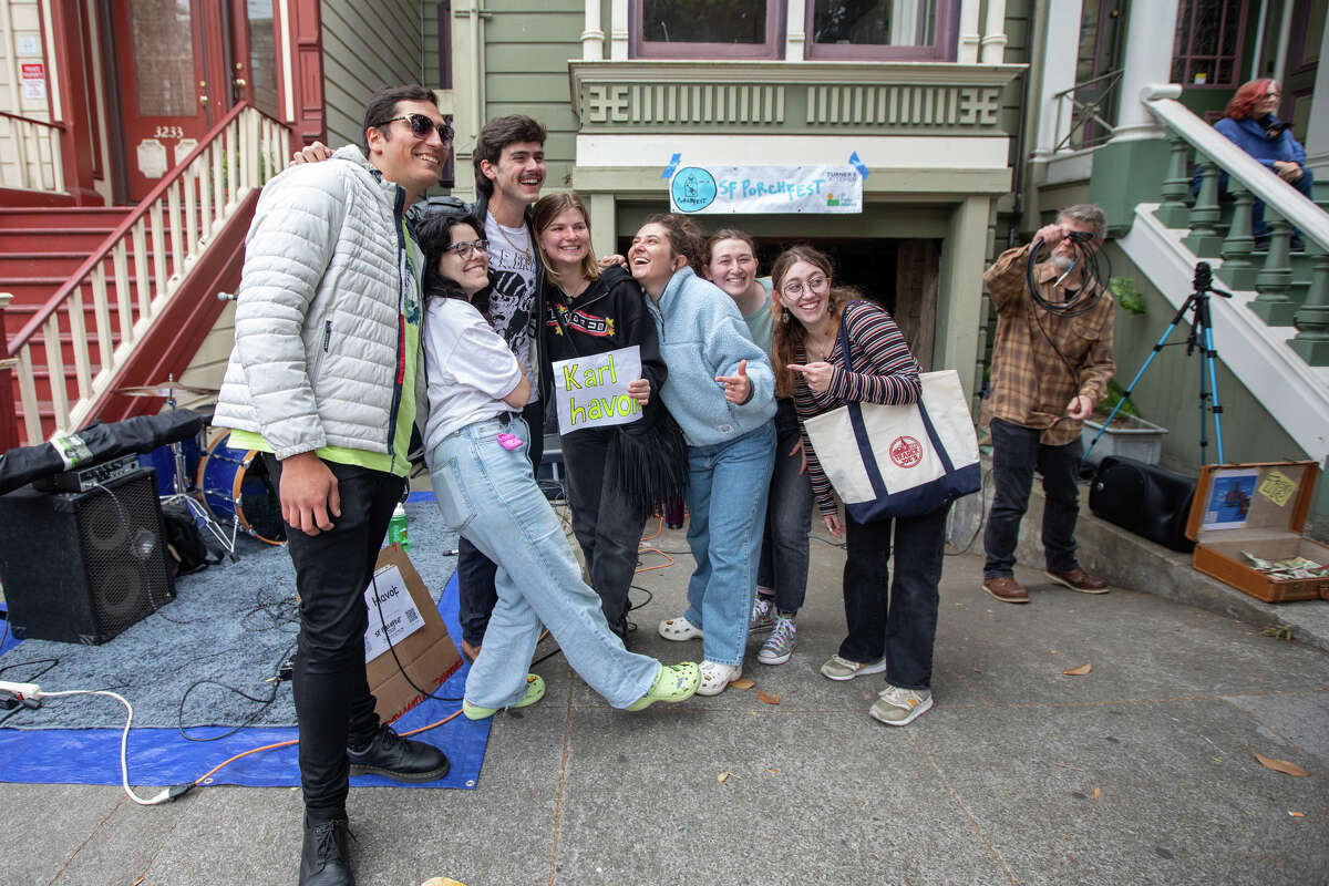 El músico Karl Havok, tercero desde la izquierda, se toma una foto con fanáticos frente a una casa en 21st Street después de su actuación en Porchfest 2023, una fiesta comunitaria musical, en el Distrito de la Misión de San Francisco, el 10 de junio de 2023.