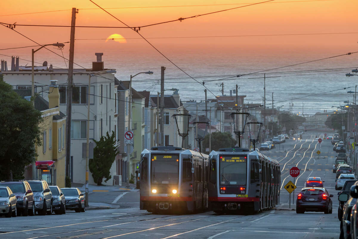 Un par de vagones de tren ligero de Muni Metro se cruzan en el vecindario Outer Sunset de San Francisco. 