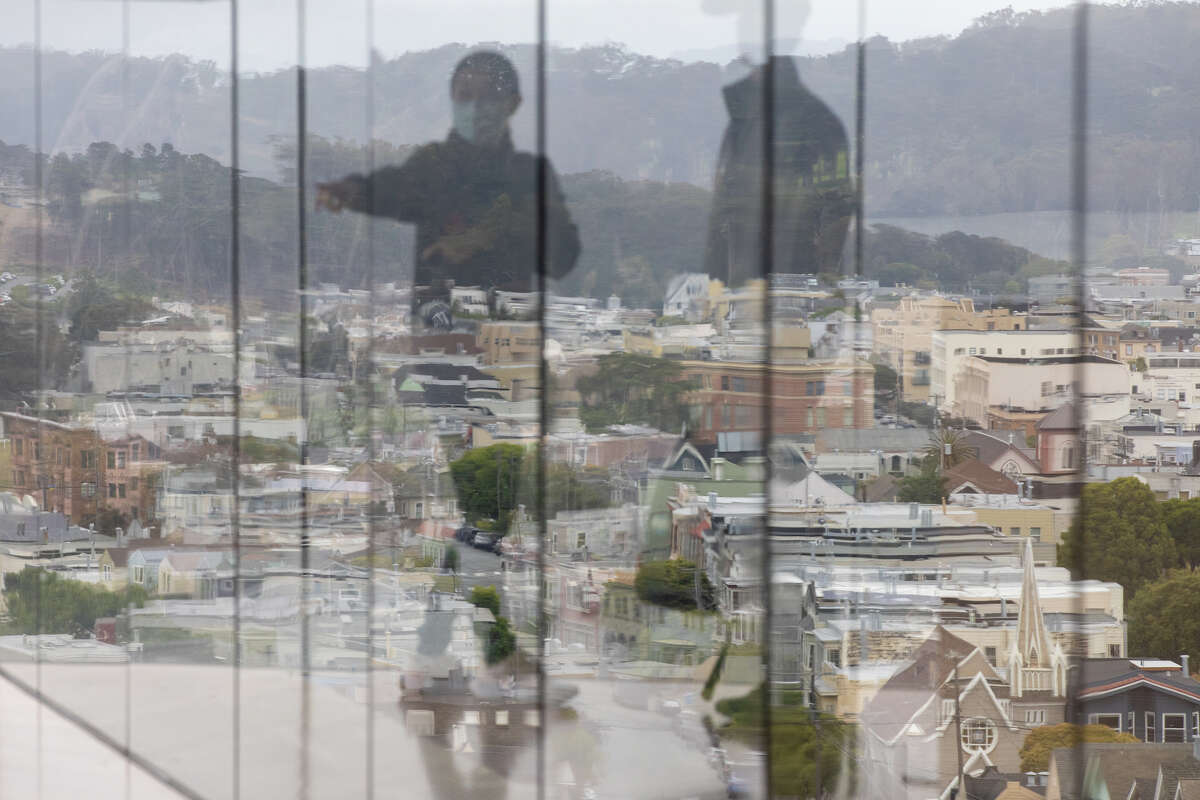 El reflejo de los visitantes que disfrutan de la vista se ve en la ventana de la torre de observación Hamon sobre el Museo de Young en el Golden Gate Park en San Francisco.