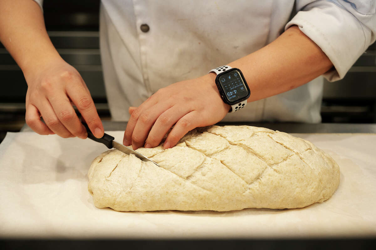 Chef corta masa de pan en Croissante en Santa Clara California, 20 de junio de 2023