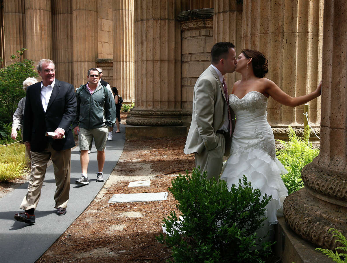 Los visitantes del Palacio de Bellas Artes ven a los recién casados ​​Joshua y Leah Smalley posar para las fotos de su boda en San Francisco, California, el sábado 2 de junio de 2012.