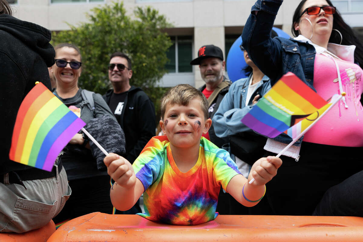 Harrison Kappler ondea banderas del Orgullo mientras observa el Desfile del Orgullo Gay anual de San Francisco el 25 de junio de 2023. Foto de Magali Gauthier.