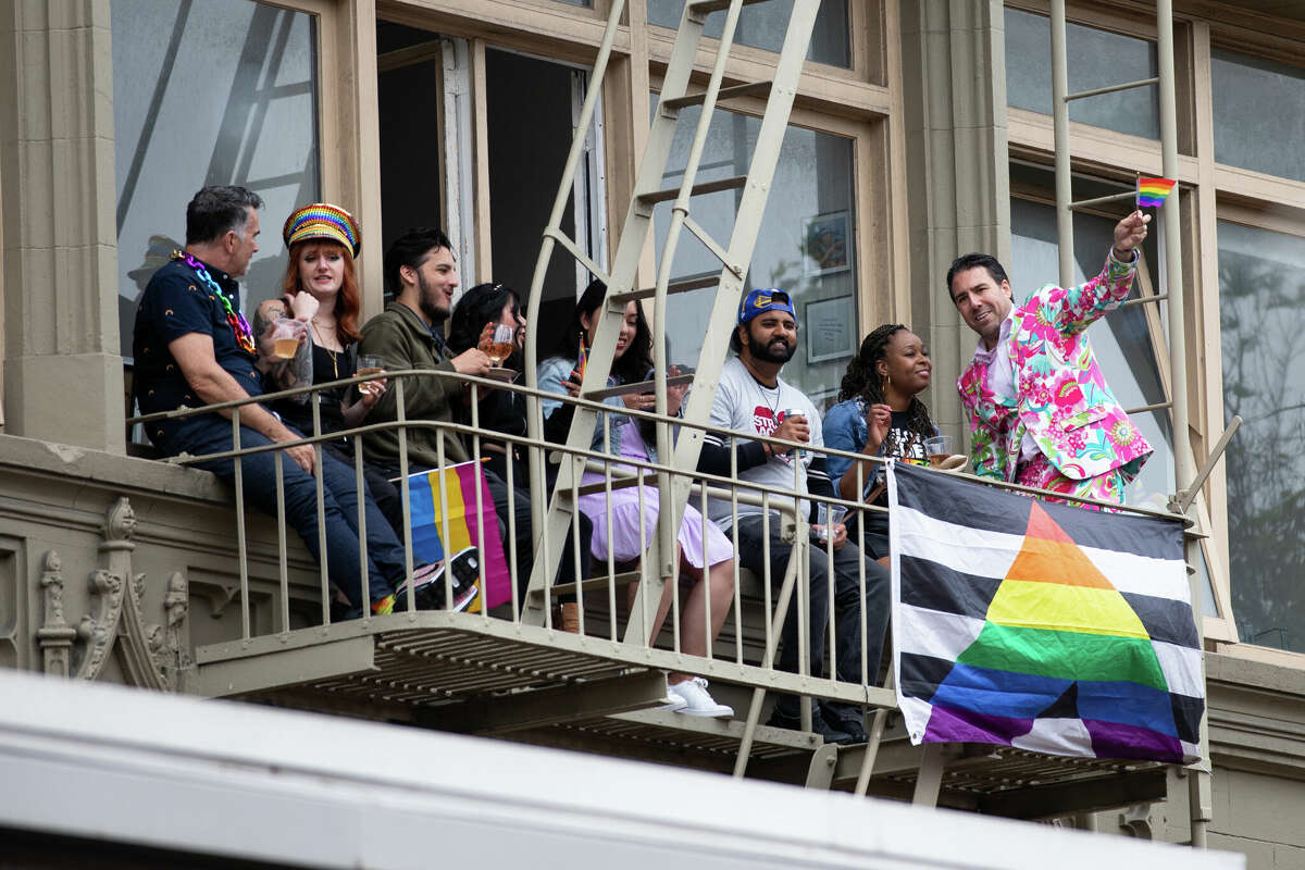 Los espectadores observan el Desfile del Orgullo Gay anual de San Francisco desde una escalera de incendios en Market Street el 25 de junio de 2023. Foto de Magali Gauthier.