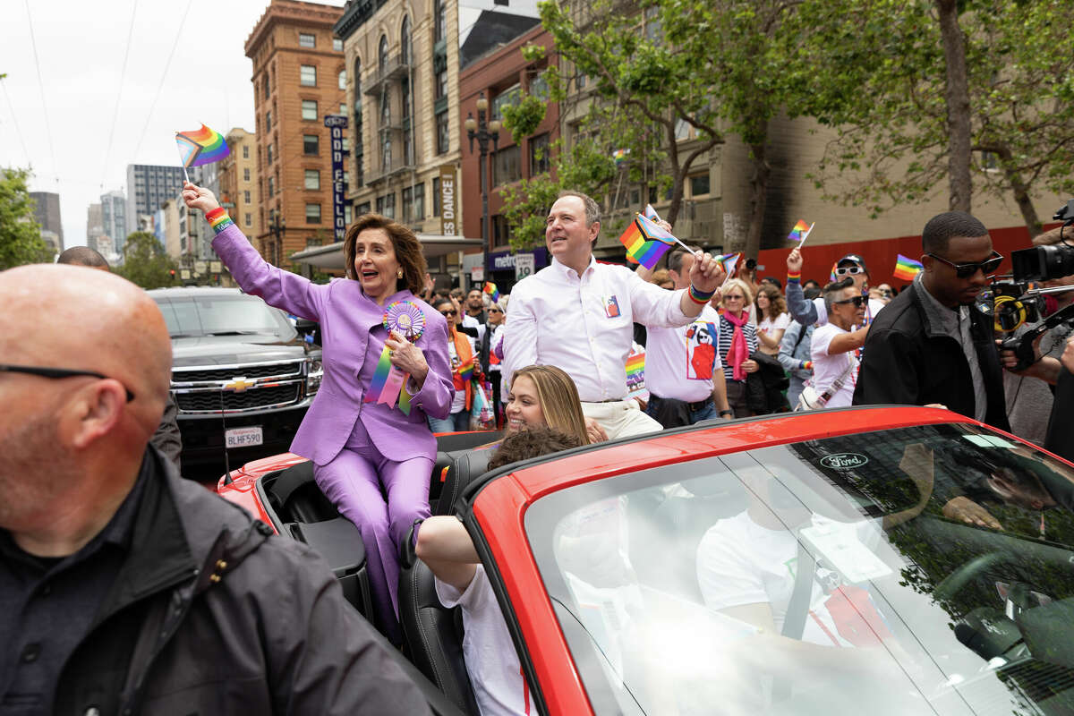 La presidenta emérita de la Cámara de Representantes, Nancy Pelosi, a la izquierda, y el representante Adam Schiff, a la derecha, ondean banderas del Orgullo Gay mientras participan en el Desfile del Orgullo Gay anual de San Francisco el 25 de junio de 2023. Foto de Magali Gauthier.