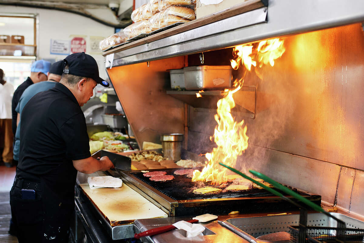 Los empleados preparan hamburguesas en Lucky Boy en Pasadena, California, el jueves.